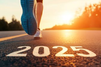 Juoksijan jalka tiellä, johon on kirjoitettu vuosiluku 2025 ja taustalla auringonlasku.