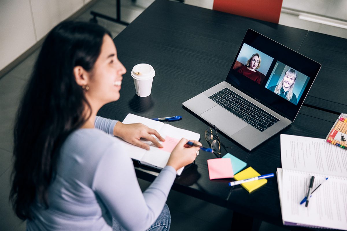 Nainen työskentelee modernissa toimistossa työpöydän äärellä.