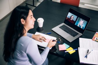 Nainen työskentelee modernissa toimistossa työpöydän äärellä.